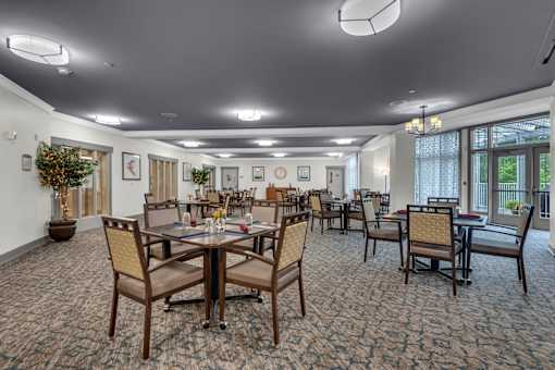 A large room with tables and chairs and a carpet.