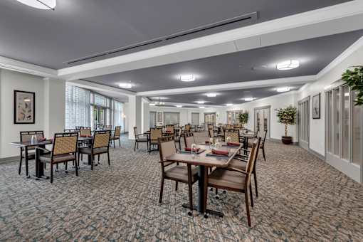 A large room with tables and chairs is set up for a meeting or event.