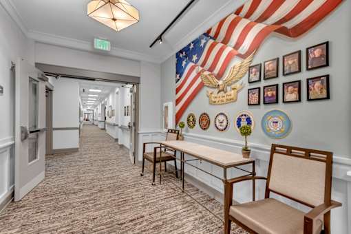 A hallway with a large American flag and a series of plaques on the wall.