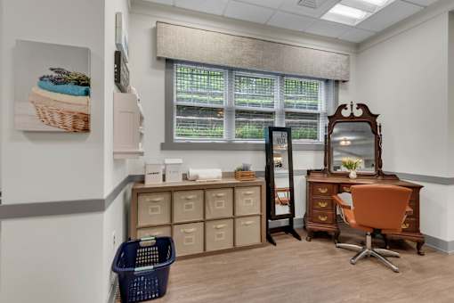 A room with a desk, chair, and storage drawers.