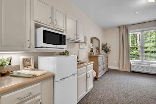 A kitchen with white appliances and cabinets.