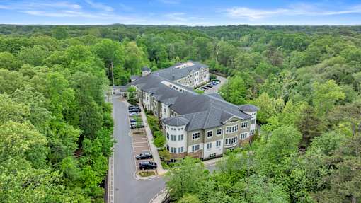 A bird's eye view of a large building surrounded by trees.
