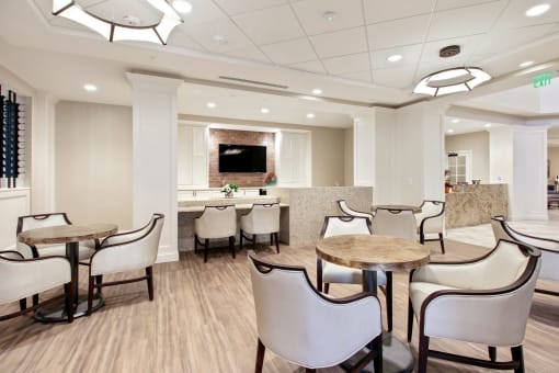 A conference room with a table and chairs and a television on the wall. at White Springs Senior Living, Warrenton, VA