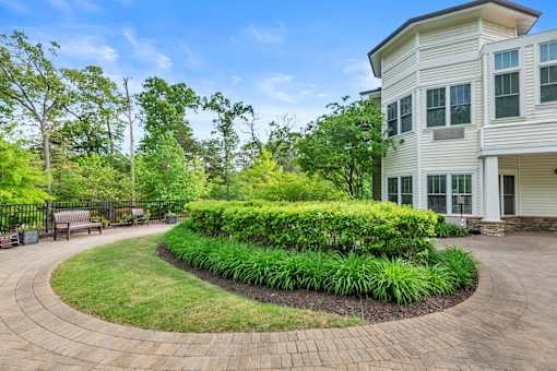 A white house with a landscaped front yard.
