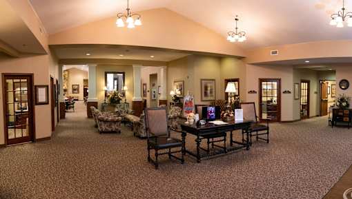 A large room with a table and chairs in the middle.
