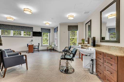 A well-lit room with a vanity table and chairs.