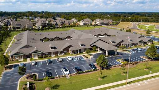 A large building complex with a parking lot in front.