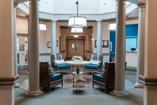 Large lobby with chairs and a table in the middle at Spring Arbor of Apex