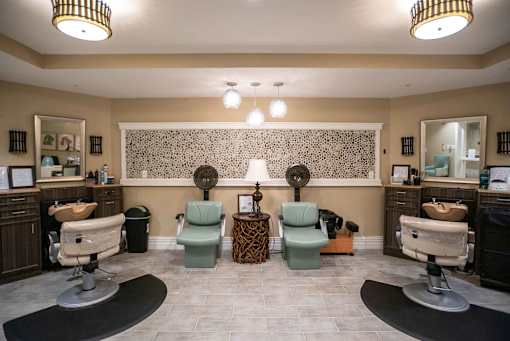 A salon with chairs and mirrors on the wall.