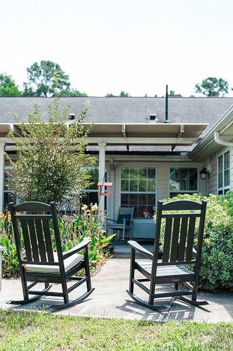 Rocking chairs on a patio at Spring Arbor of Greenville