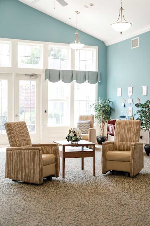 Two chairs and a table are in a room with a window at Spring Arbor of Cary in Cary, NC
