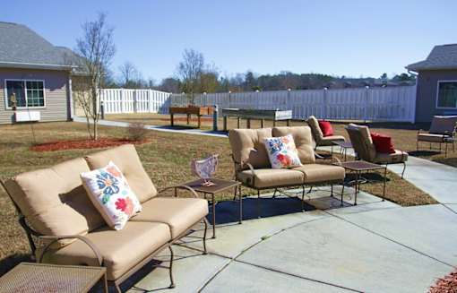 A patio with a couch and chairs.