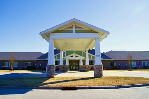 A building with a covered entrance and a stone pillar.
