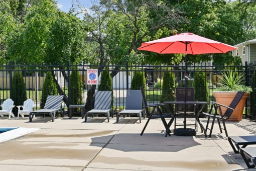 Pool deck with lounge chairs and patio furniture at Fox Run Apartments, St. Charles, IL 60174
