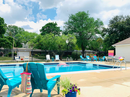 Outdoor pool with turquoise chairs and fence at Fox Run Apartments, St. Charles, Illinois