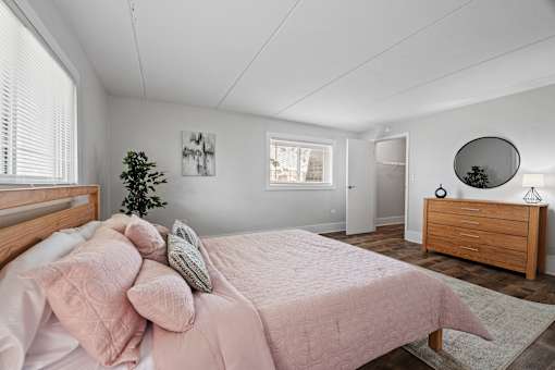 Bedroom with pink bedding and wood furnishings at Fox Run Apartments, St. Charles, 60174