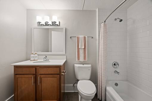 Bathroom with white subway tile and wood vanity at Fox Run Apartments, St. Charles