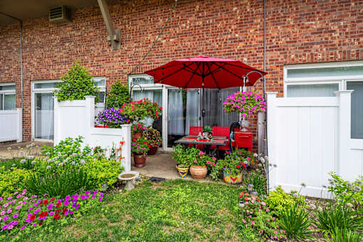Private patio with outdoor dining and umbrella at Fox Run Apartments, St. Charles, Illinois