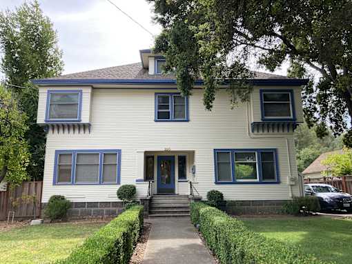 A two-story house with a blue door and windows.
