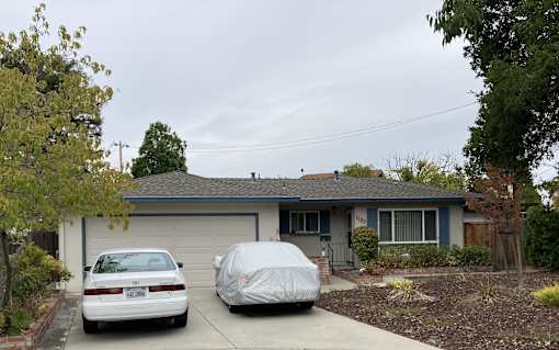 A house with a car parked in front of it.