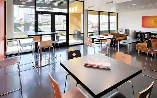 A room with tables and chairs and a book on one of the tables.