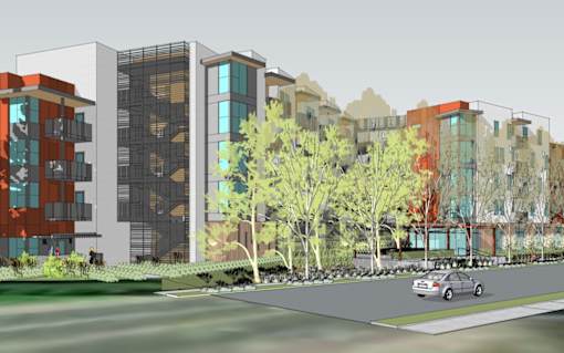 A car is parked on the side of a road in front of a row of buildings.