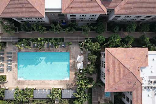 A swimming pool surrounded by trees and buildings.