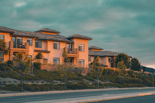 A row of houses with orange walls and black roofs.