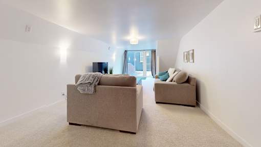 Two beige couches in a room with a door in the background.