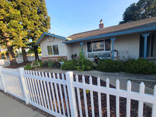A white picket fence in front of a house.