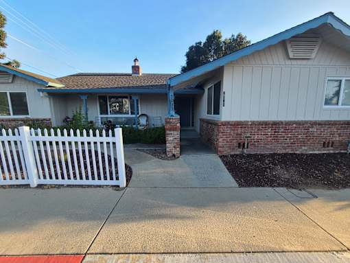 A house with a white picket fence in front.