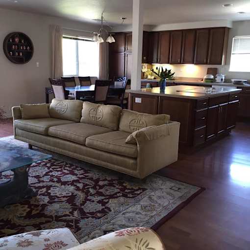 A beige couch with a pillow on it in a living room.