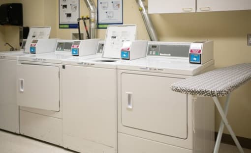 a row of washers and dryers in a laundromat