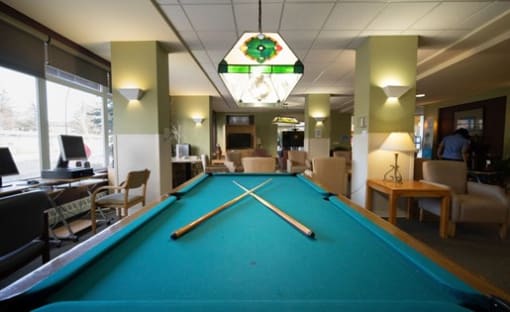 a large room with a pool table and a chandelier