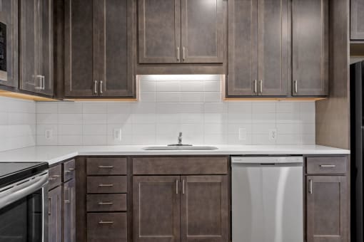 an empty kitchen with wooden cabinets and a white counter top