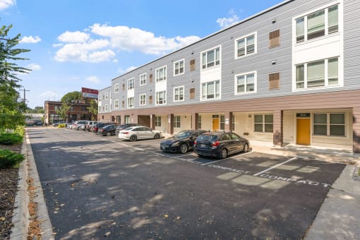 a large apartment building with cars parked in front of it
