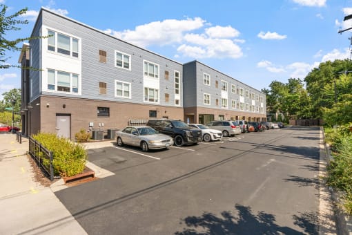 a parking lot with cars in front of an apartment building