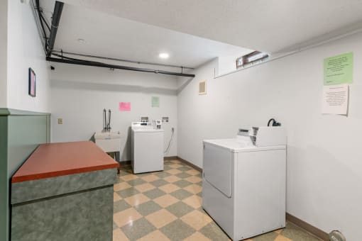 a room with two washing machines and a counter and a refrigerator