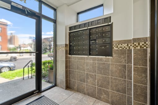 the front door of a building with a mail box on the wall