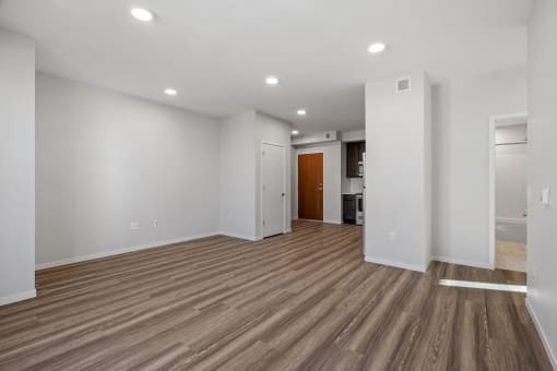 a living room with white walls and wood floors