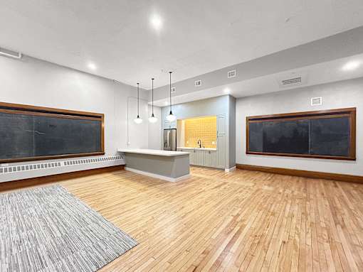 the living room has a wood floor and a large screen tv