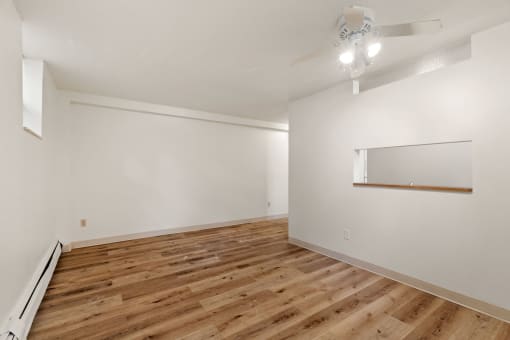 a living room with white walls and wood floors