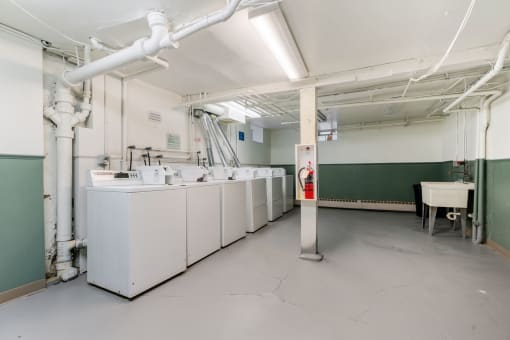 a large white room with white washing machines and a red fire hydrant