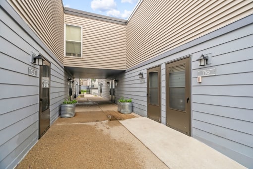 the entrance to a building with three doors and a sidewalk