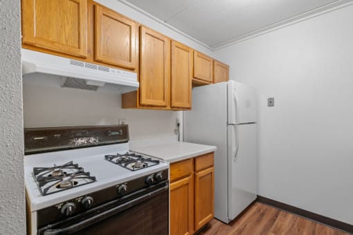 a kitchen with white appliances and wooden cabinets and a refrigerator