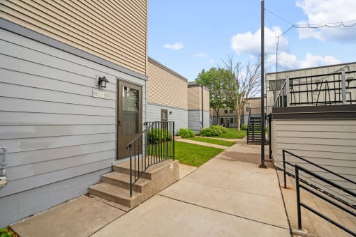 a sidewalk in front of a building with stairs