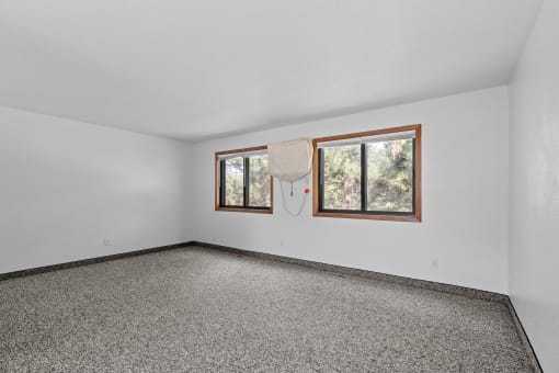 the living room of a house with a window and carpet