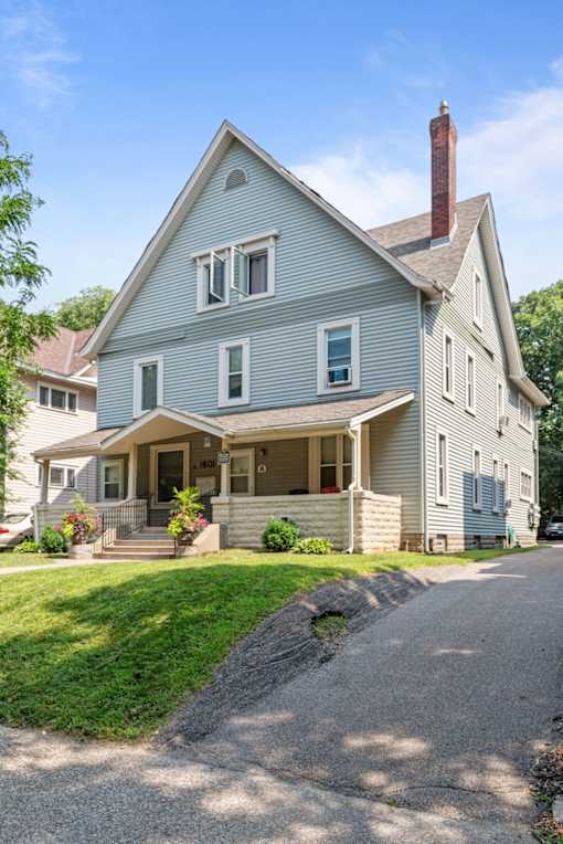 a blue house with a porch and a driveway