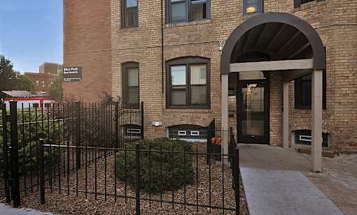 a brick building with a gate and a sidewalk in front of it