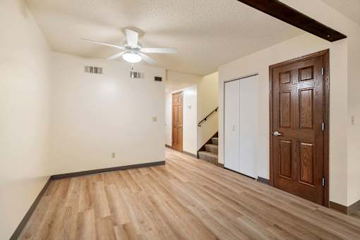 A room with a wooden floor and a ceiling fan.